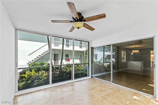 unfurnished room with ceiling fan and expansive windows