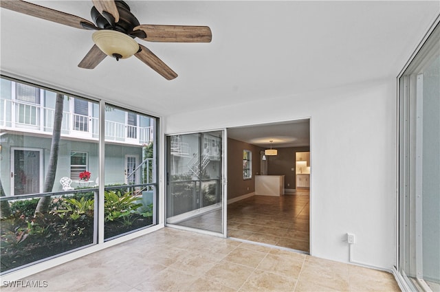 unfurnished sunroom featuring ceiling fan