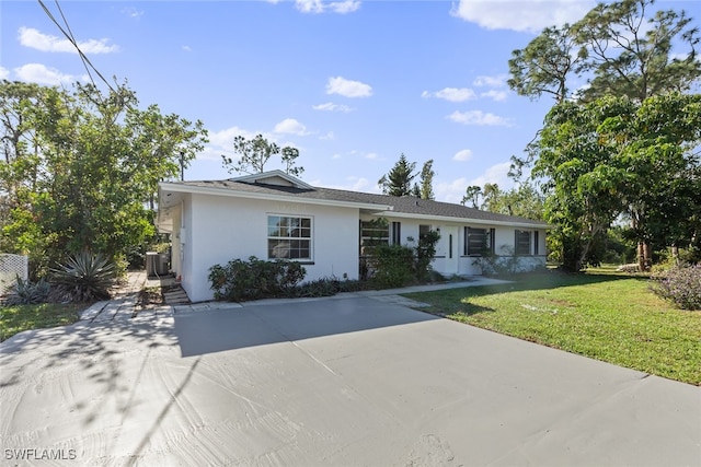 single story home featuring a front yard and central AC unit