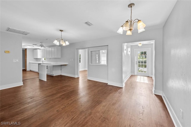 interior space featuring dark hardwood / wood-style flooring and ceiling fan with notable chandelier