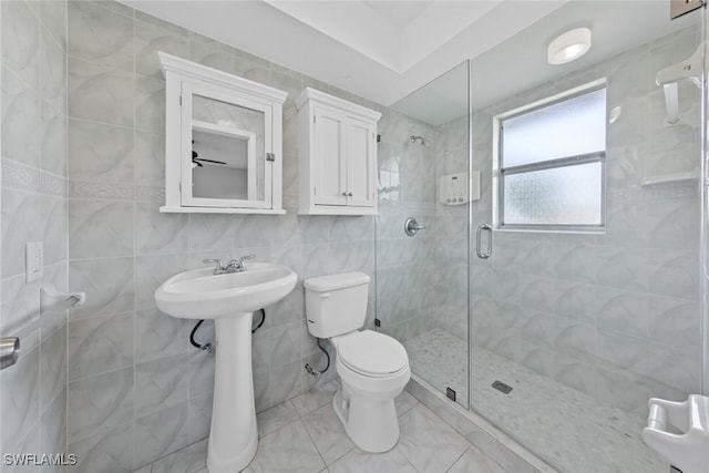 bathroom with walk in shower, toilet, and tile walls