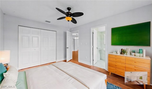 bedroom with ceiling fan, wood-type flooring, ensuite bath, and a closet