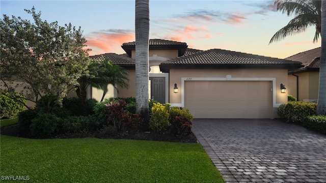 mediterranean / spanish-style home featuring a yard and a garage