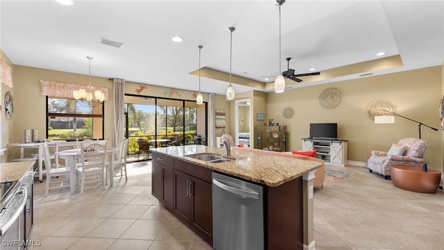 kitchen featuring sink, light stone counters, stainless steel dishwasher, decorative light fixtures, and a tray ceiling