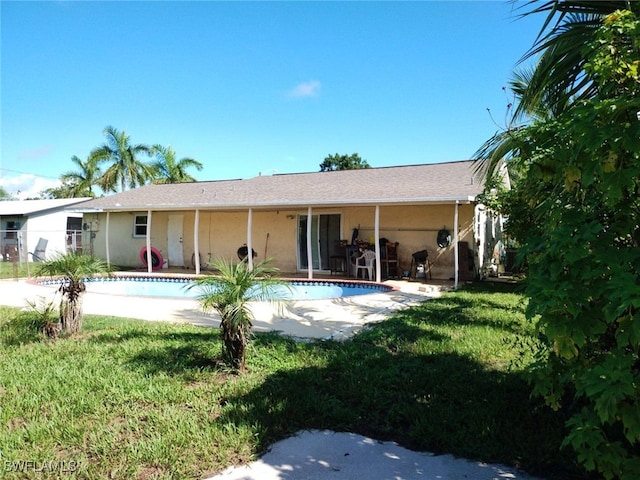 back of house featuring a patio area and a lawn