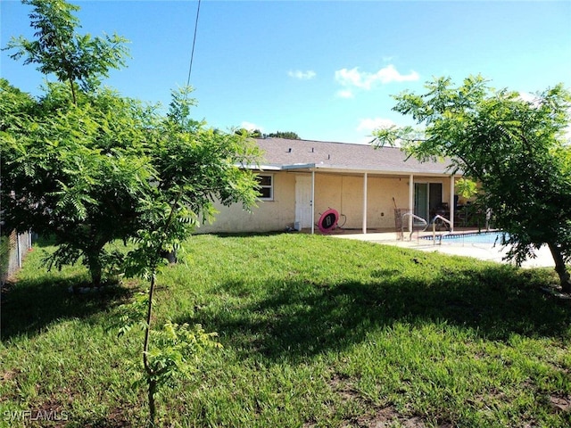 rear view of house with a yard and a patio