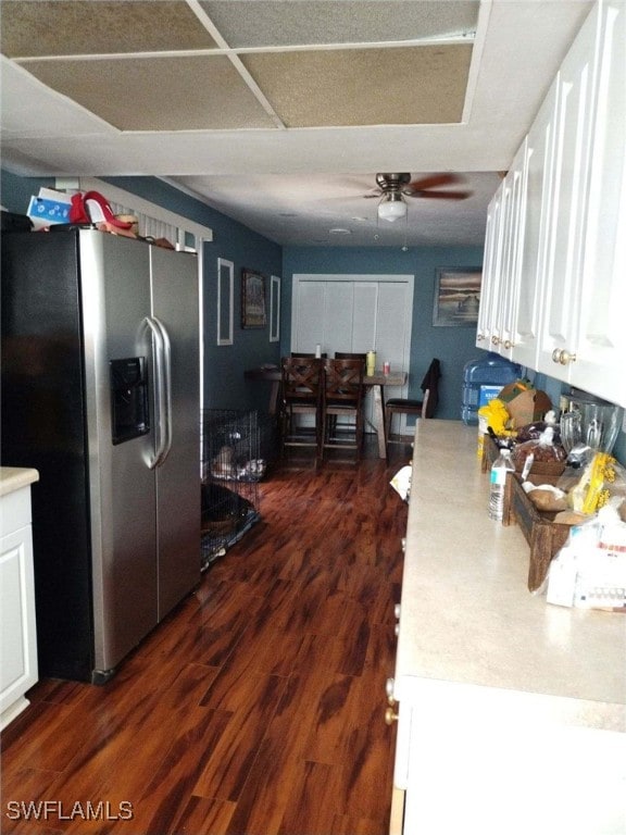 kitchen with stainless steel refrigerator with ice dispenser, dark wood-type flooring, white cabinets, and ceiling fan