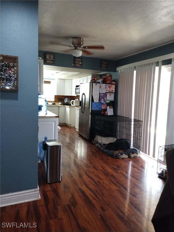 living room featuring ceiling fan, dark hardwood / wood-style flooring, and a textured ceiling