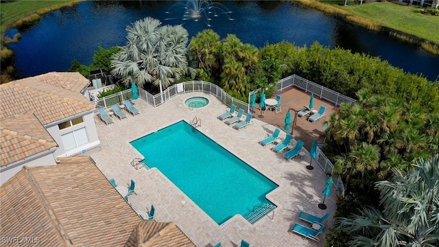 view of swimming pool featuring a patio area, a community hot tub, and a water view