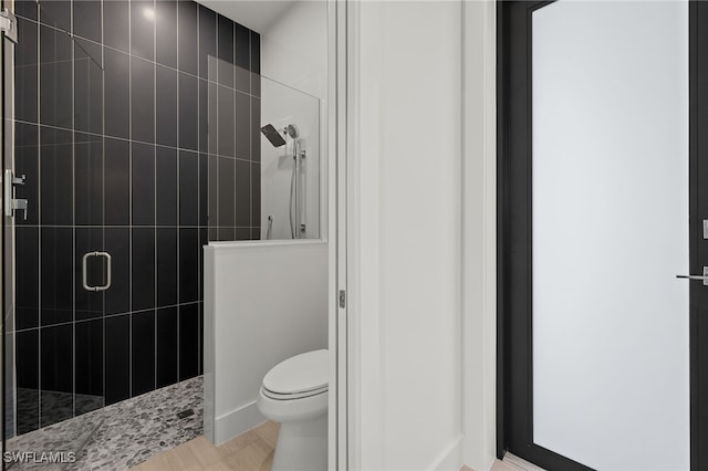 bathroom featuring hardwood / wood-style flooring, toilet, and an enclosed shower