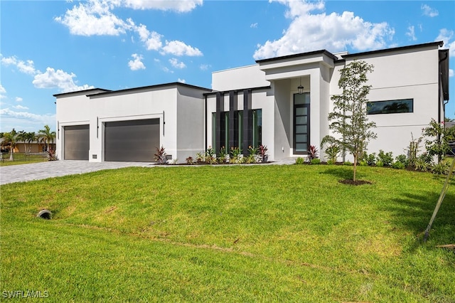 modern home featuring a front yard and a garage