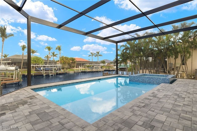 view of pool featuring a patio area, an in ground hot tub, a water view, and glass enclosure