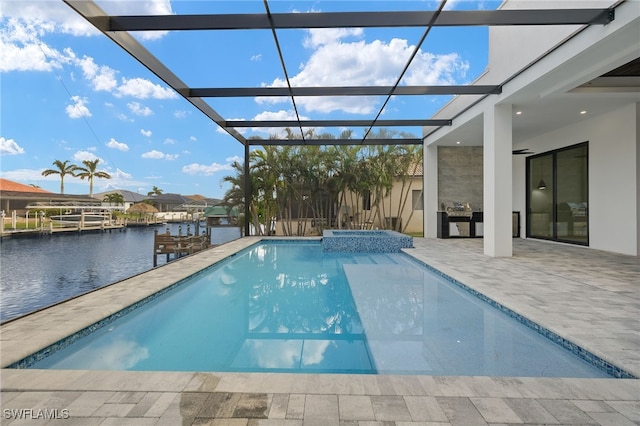 view of pool featuring a patio, an in ground hot tub, a water view, and glass enclosure