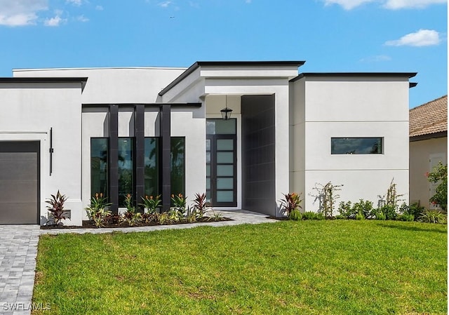 view of exterior entry with a yard and a garage