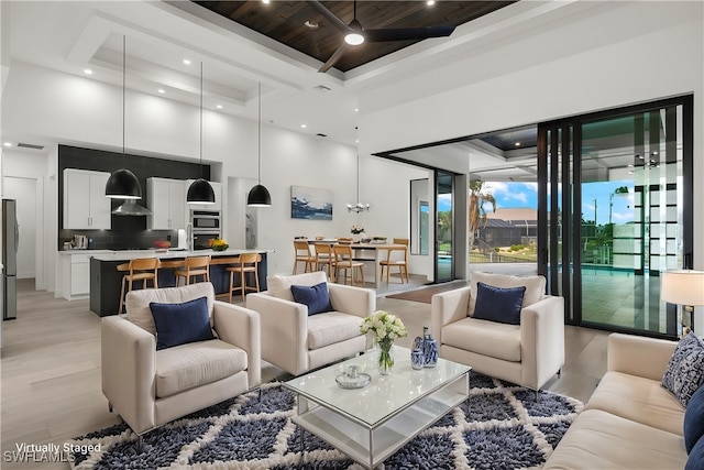 living room with light hardwood / wood-style floors and a towering ceiling