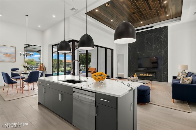 kitchen with dishwasher, sink, an island with sink, and pendant lighting