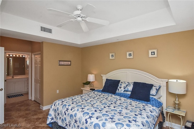 bedroom featuring ceiling fan, tile patterned floors, a tray ceiling, and sink