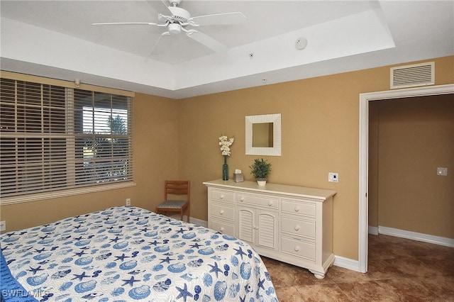 bedroom featuring a raised ceiling and ceiling fan