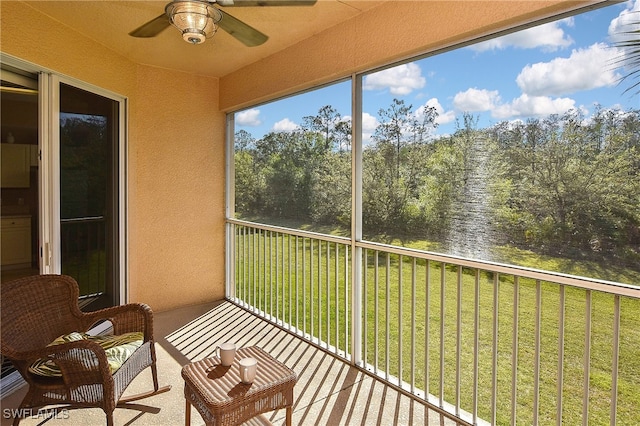 unfurnished sunroom featuring a water view and ceiling fan