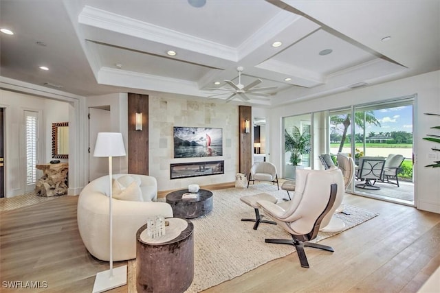 living room featuring crown molding, a tile fireplace, beam ceiling, coffered ceiling, and light hardwood / wood-style floors