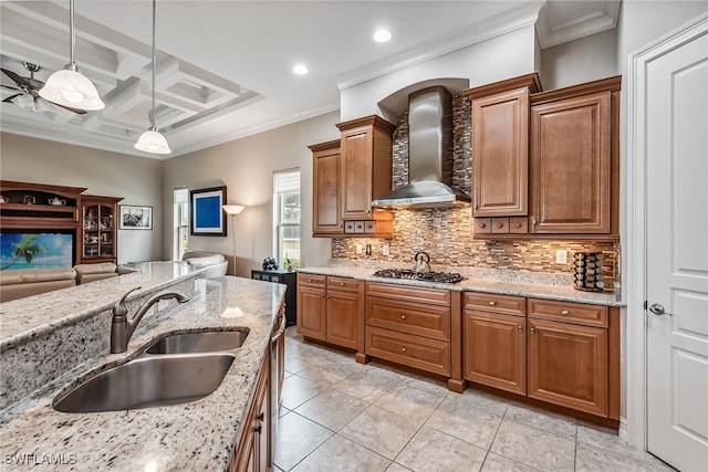 kitchen with wall chimney exhaust hood, decorative light fixtures, crown molding, light stone countertops, and ceiling fan