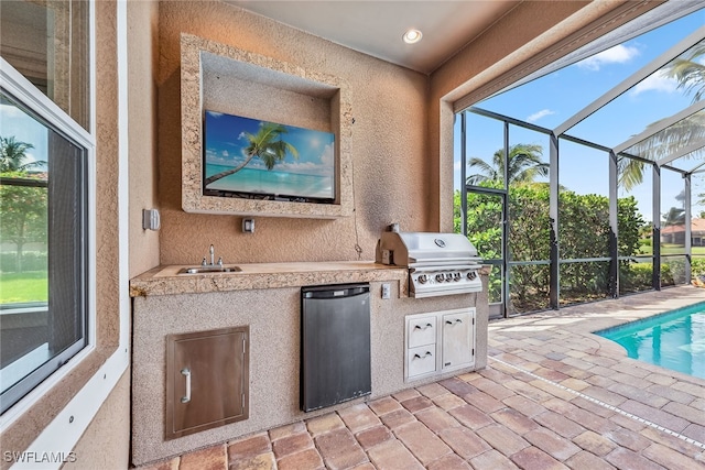 view of patio / terrace with glass enclosure, area for grilling, sink, and an outdoor kitchen