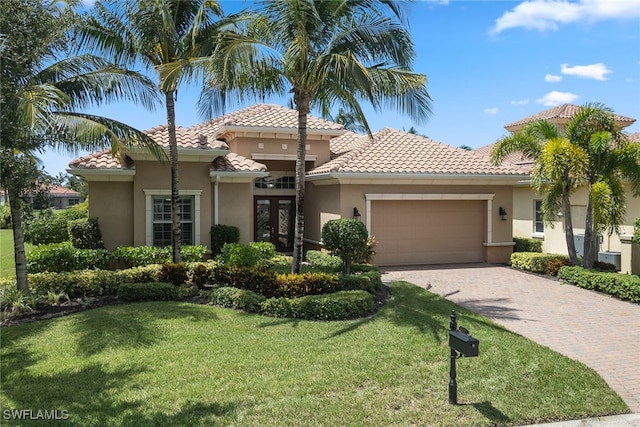 mediterranean / spanish-style house featuring a front yard and a garage