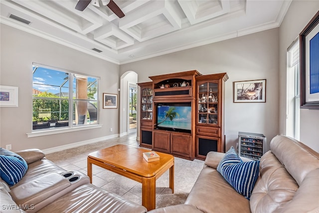 tiled living room with ornamental molding, beamed ceiling, ceiling fan, and coffered ceiling