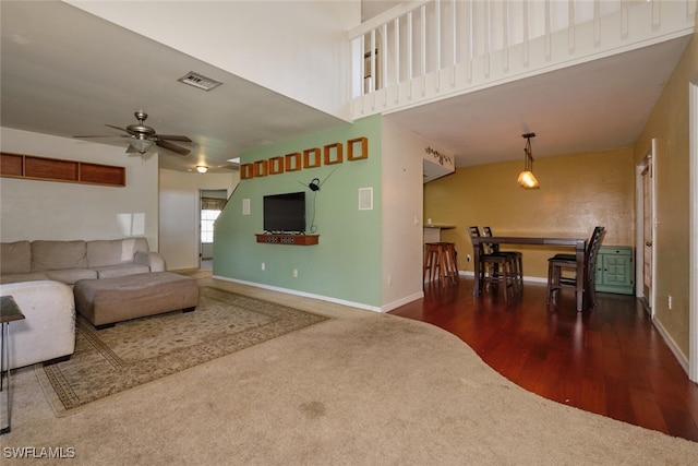 living room with dark hardwood / wood-style flooring and ceiling fan