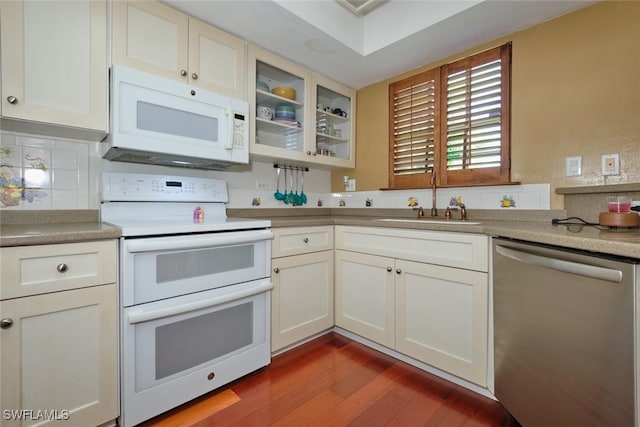 kitchen with light wood-type flooring, white appliances, sink, and tasteful backsplash