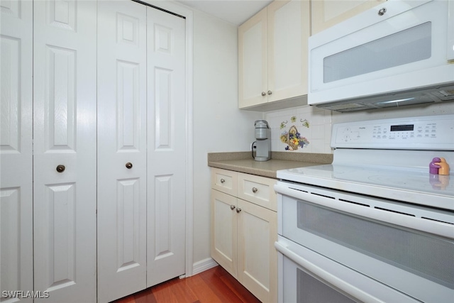 kitchen featuring white appliances, dark wood-type flooring, and tasteful backsplash