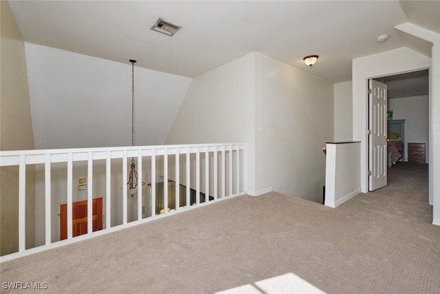 carpeted spare room featuring a chandelier and vaulted ceiling