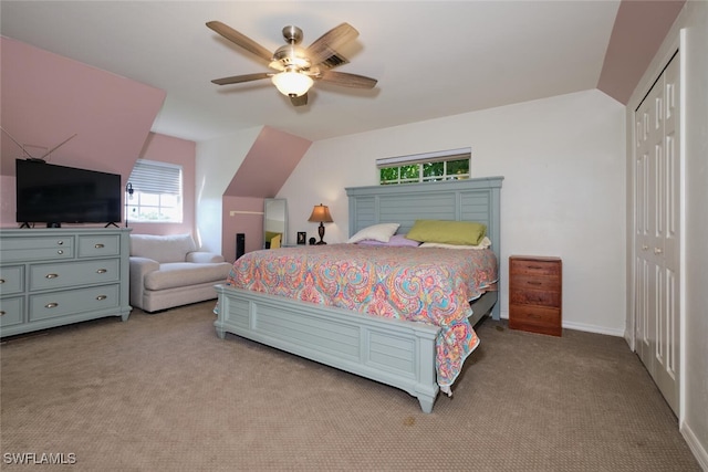 bedroom featuring ceiling fan, a closet, light carpet, and lofted ceiling