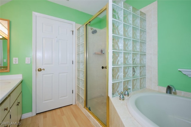 bathroom with independent shower and bath, vanity, and hardwood / wood-style floors