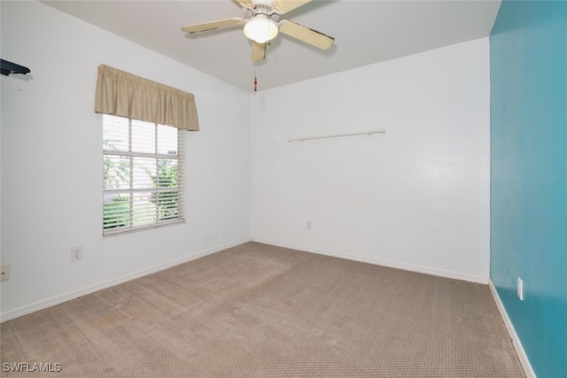 carpeted spare room featuring ceiling fan