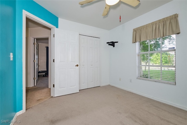 unfurnished bedroom with ceiling fan, light colored carpet, and a closet