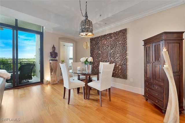 dining area featuring crown molding and light hardwood / wood-style flooring