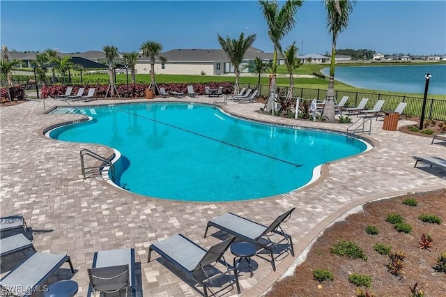 view of pool featuring a water view and a patio