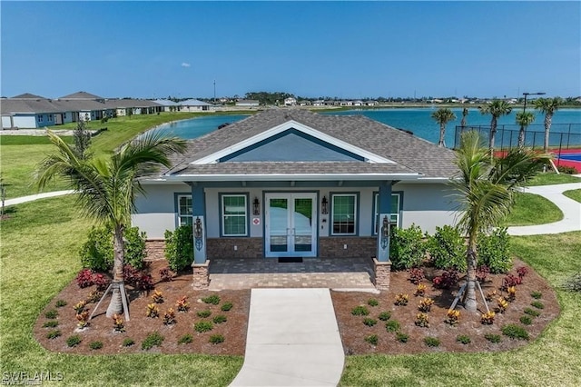 view of front of property featuring covered porch, a front lawn, and a water view