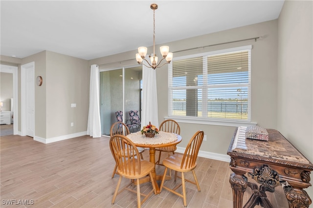 dining area with light hardwood / wood-style floors and a chandelier