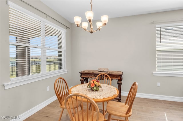 dining room with a chandelier, light wood-type flooring, and plenty of natural light