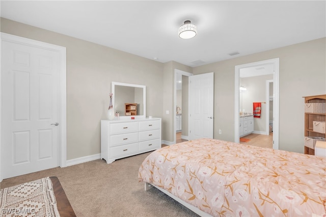 bedroom with light carpet and ensuite bath