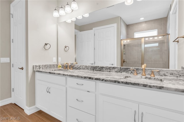 bathroom with a shower with door, vanity, and hardwood / wood-style flooring