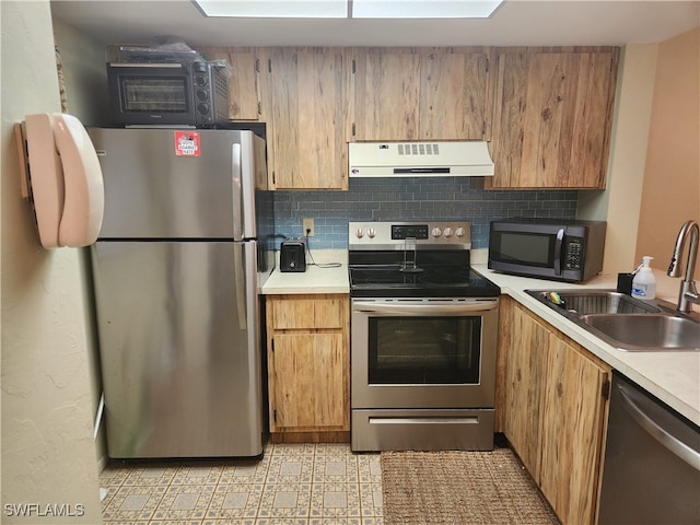 kitchen with appliances with stainless steel finishes, tasteful backsplash, and sink