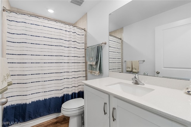 bathroom featuring curtained shower, hardwood / wood-style flooring, vanity, and toilet