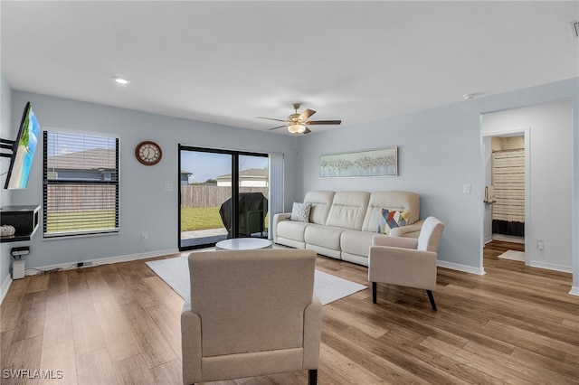 living room with light hardwood / wood-style flooring and ceiling fan