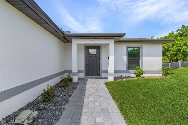 entrance to property featuring a yard