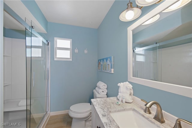 bathroom featuring vanity, tile patterned flooring, toilet, and a shower with door