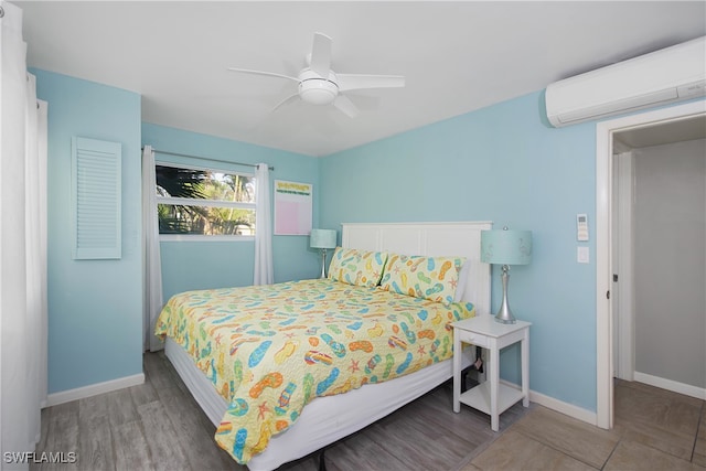 bedroom featuring hardwood / wood-style floors, ceiling fan, and a wall unit AC