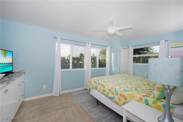 tiled bedroom featuring a closet, ceiling fan, and multiple windows